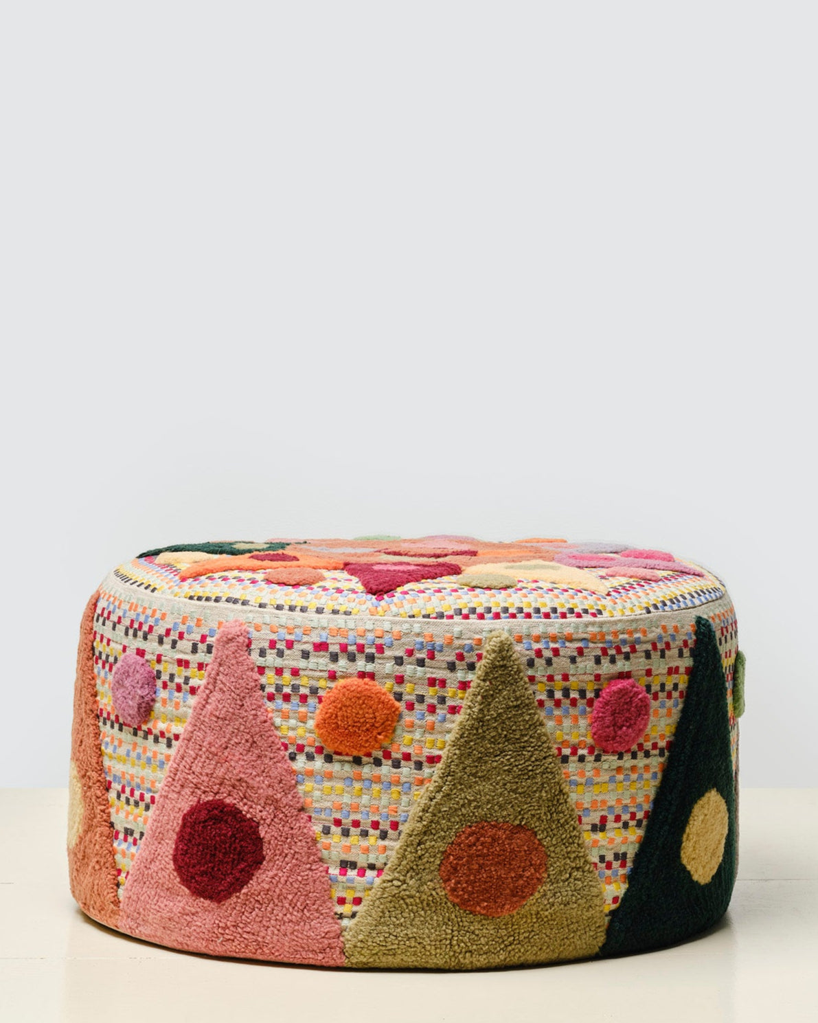 Pouff with tufted embellishment, side view