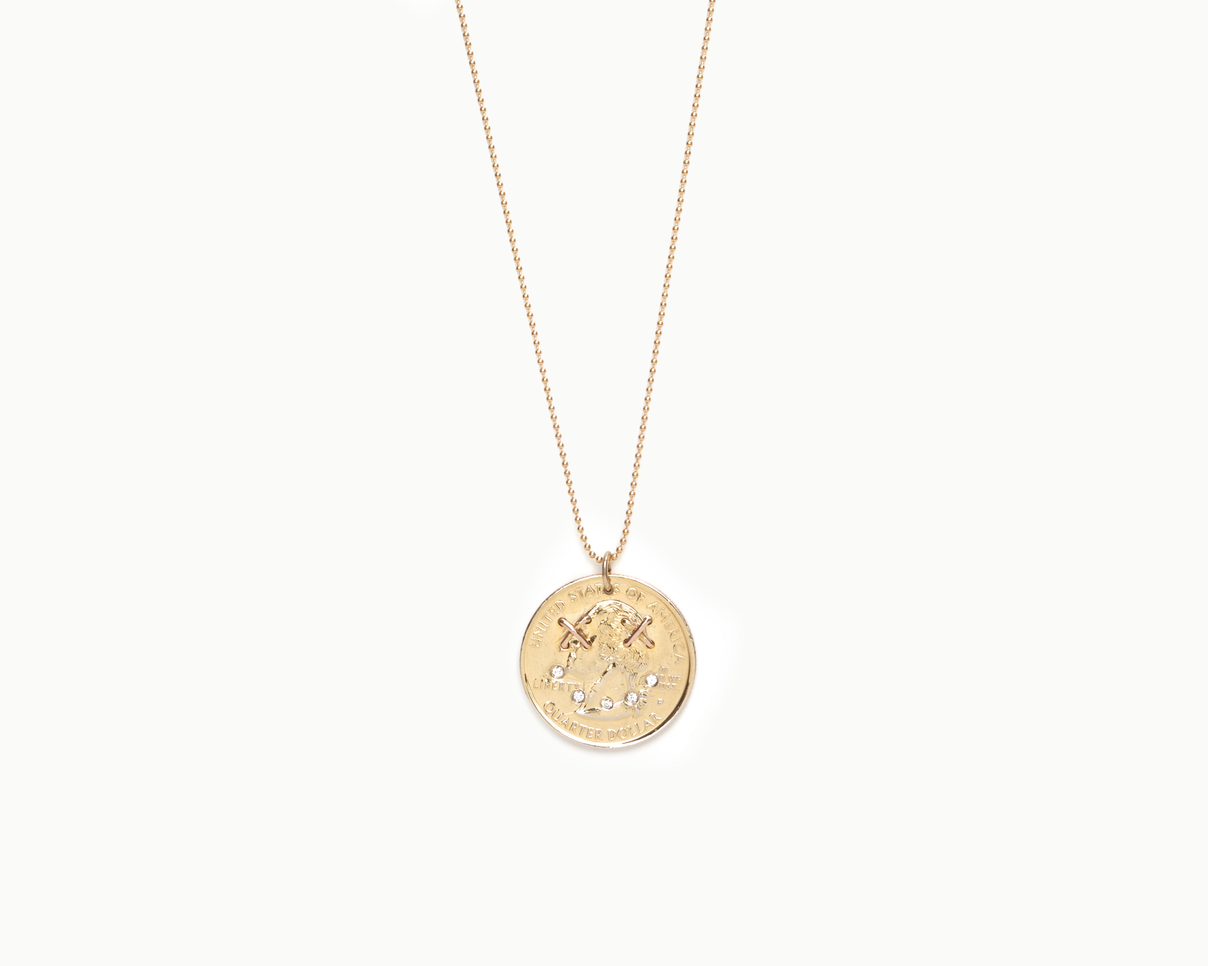 Upcycled necklace with gold plated quarter with diamond smile, close up view  