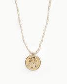 Upcycled gold plated quarter necklace on pearl stand, close up view. 