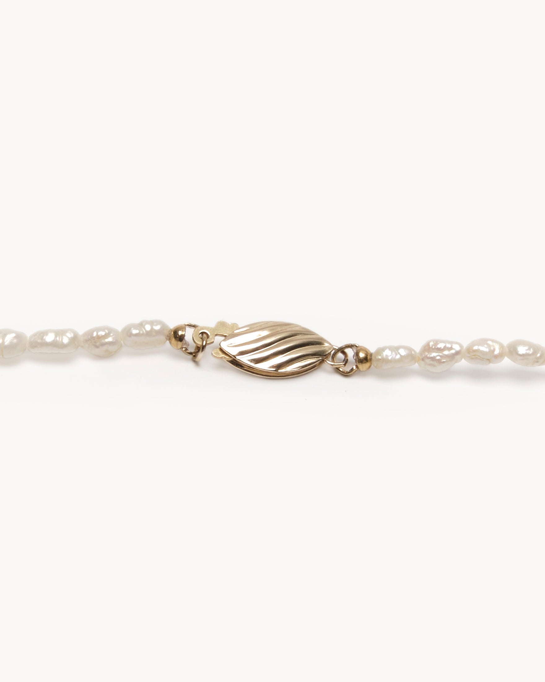 Upcycled gold plated quarter necklace on pearl stand, clasp view. 