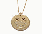 Upcycled necklace with gold plated quarter with diamond smile, close up view  