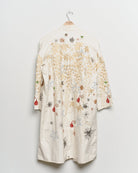 Long reworked white coat with embroidered motifs, back view. 