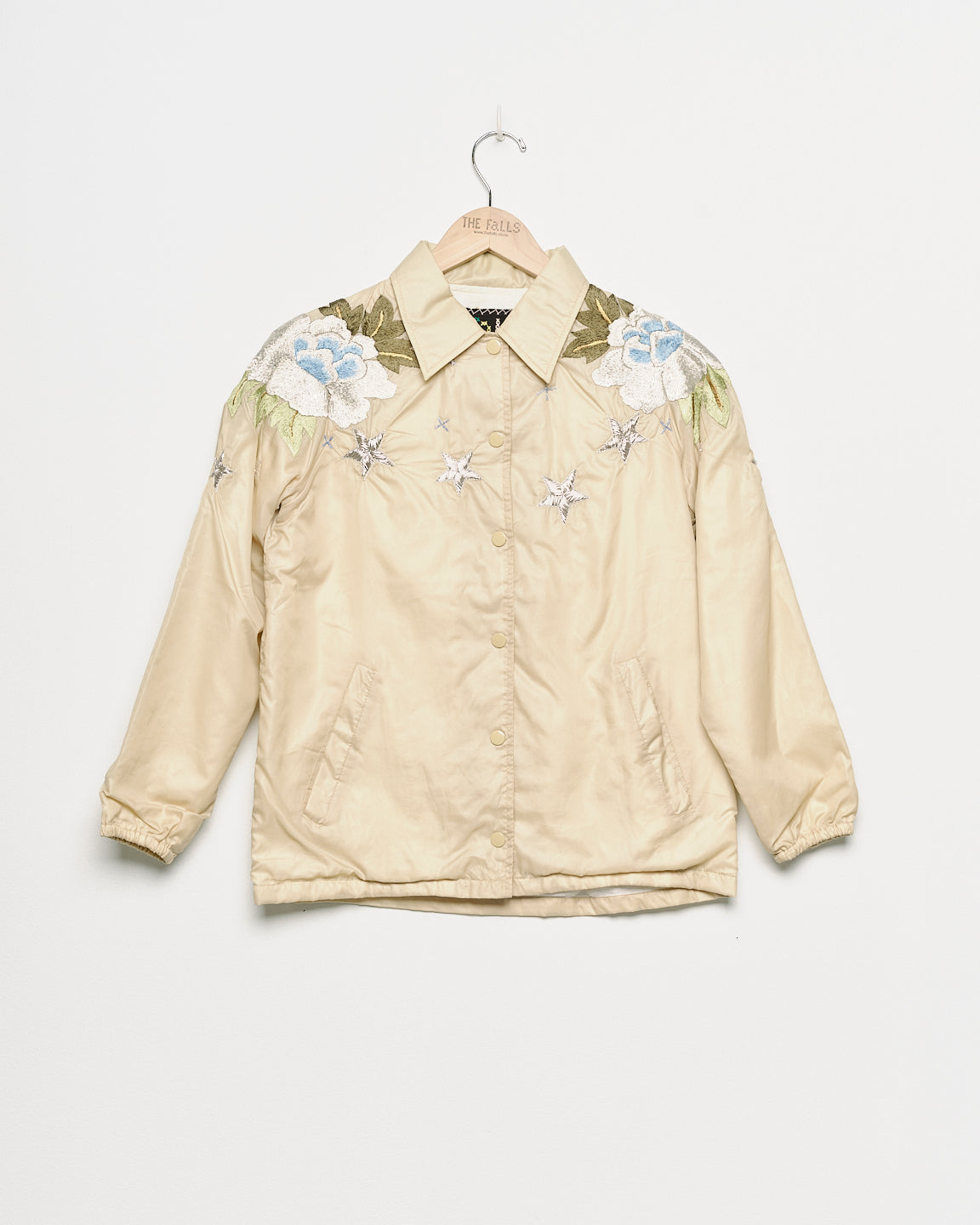Upcycled windbreaker with floral embroidery, front view. 