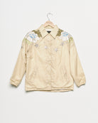 Upcycled windbreaker with floral embroidery, front view. 