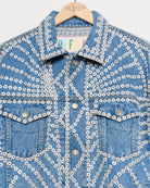 Upcycled denim jacket with pearly buttons, closeup view.