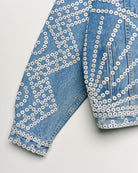 Upcycled denim jacket with pearly buttons, sleeve close up view.
