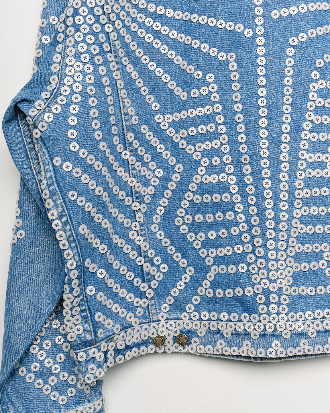Upcycled denim jacket with pearly buttons, back close up view.