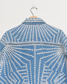 Upcycled denim jacket with pearly buttons, back close up view.