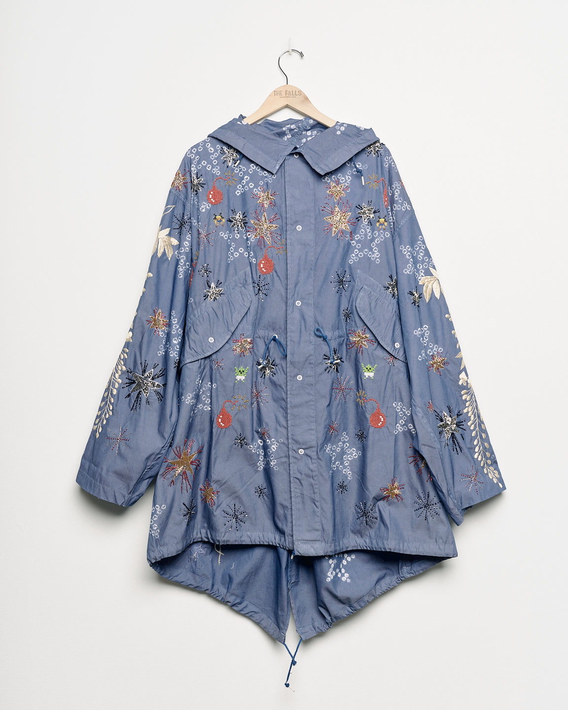 Upcycled parka with star and bomb embroidery, front view. 
