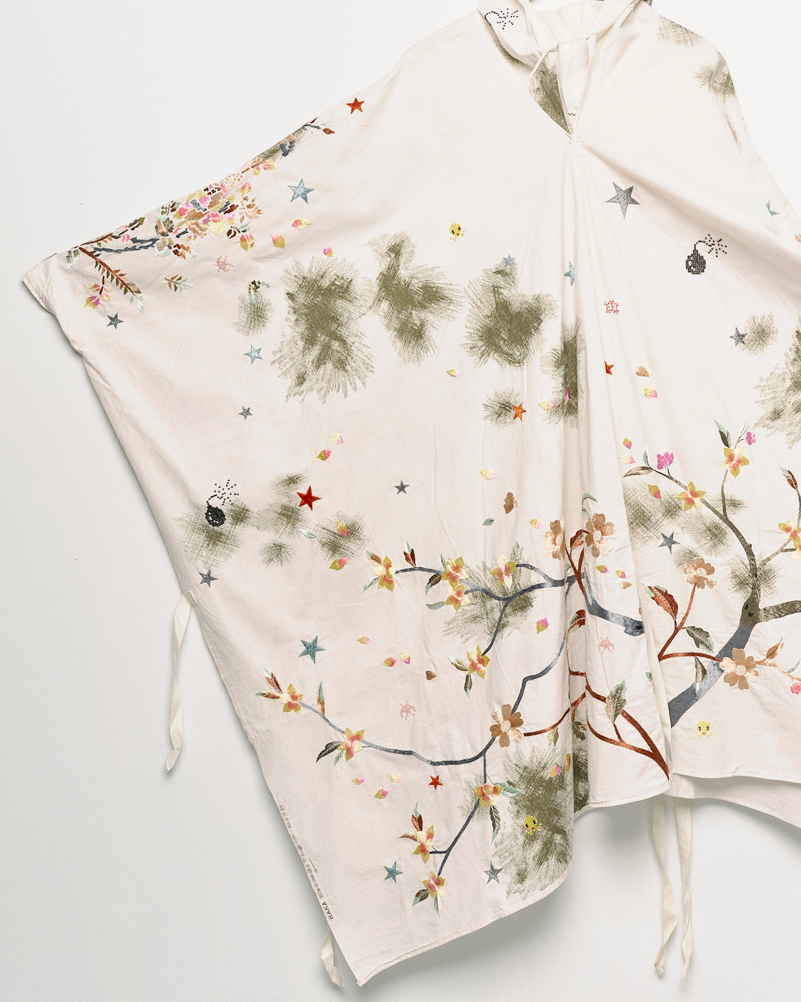 Upcycled floral snow camo hand embroidered poncho, sleeve close up view. 