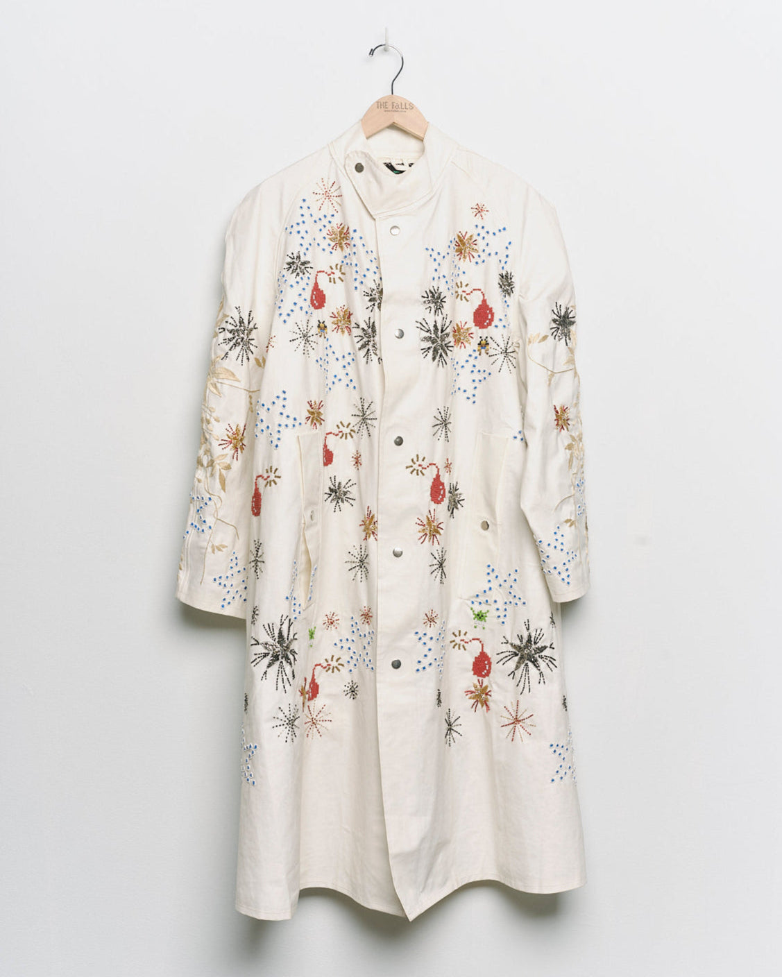 Long reworked white coat with embroidered motifs, front view. 