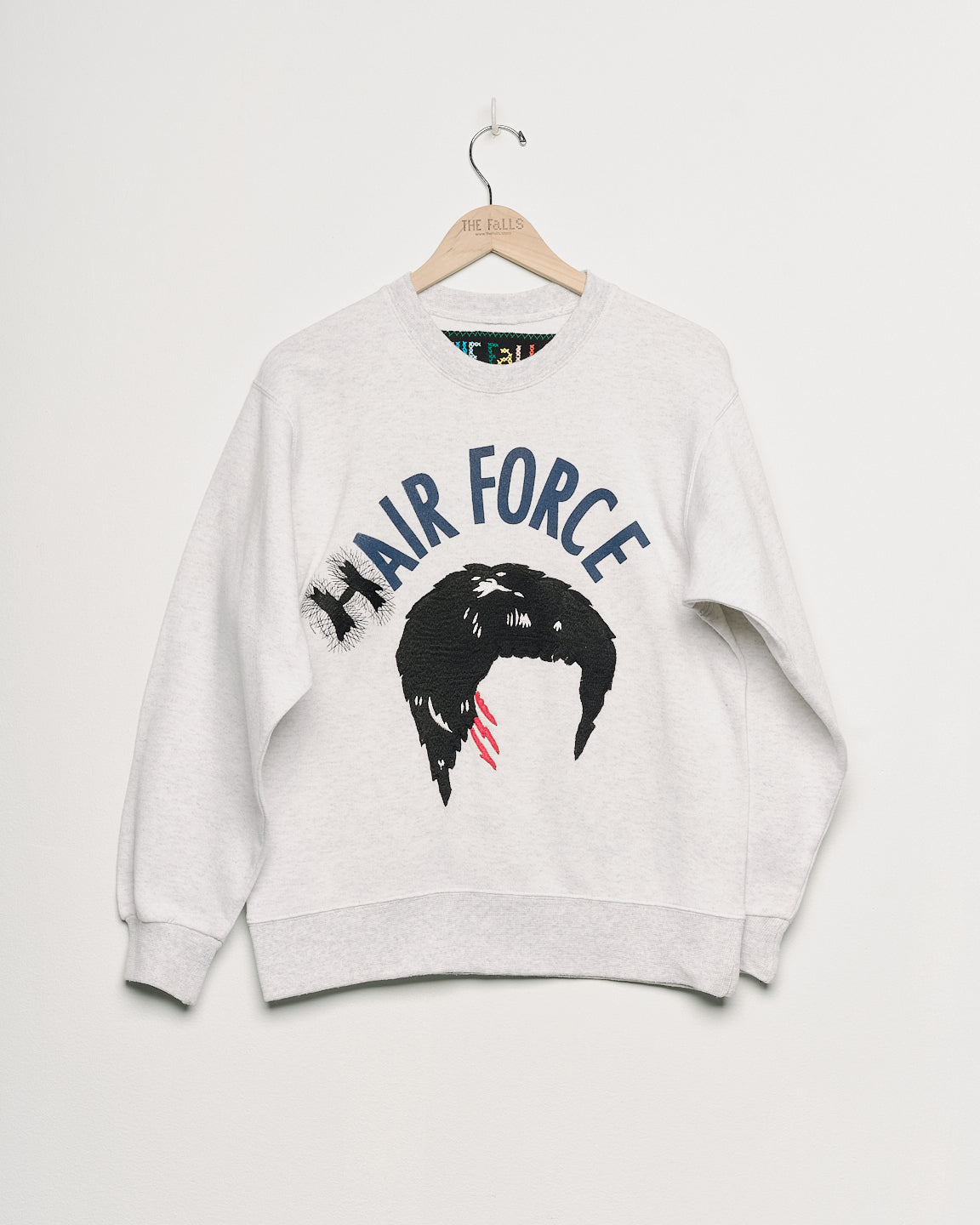 Upcycled sweatshirt with embroidery saying “hair force”, front view. 