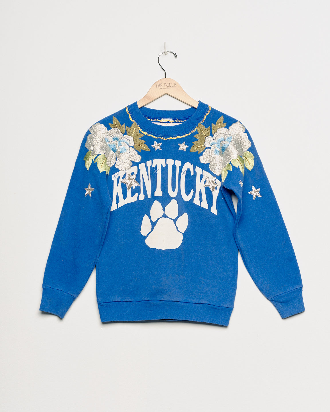 Upcycled sweatshirt with floral embroidery, front view. 
