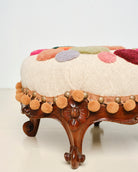 Upcycled footstool with tufted embellishments, side view 
