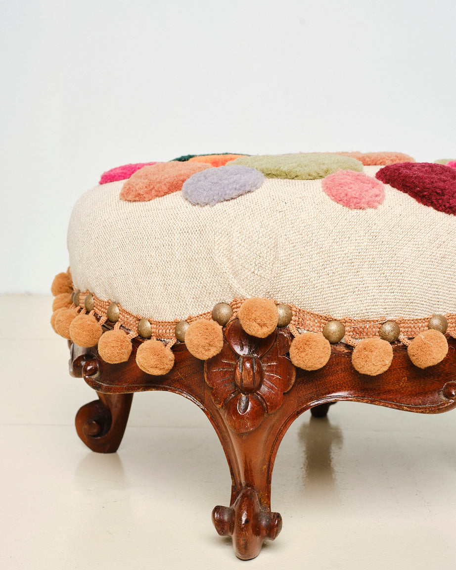 Upcycled footstool with tufted embellishments, side view 
