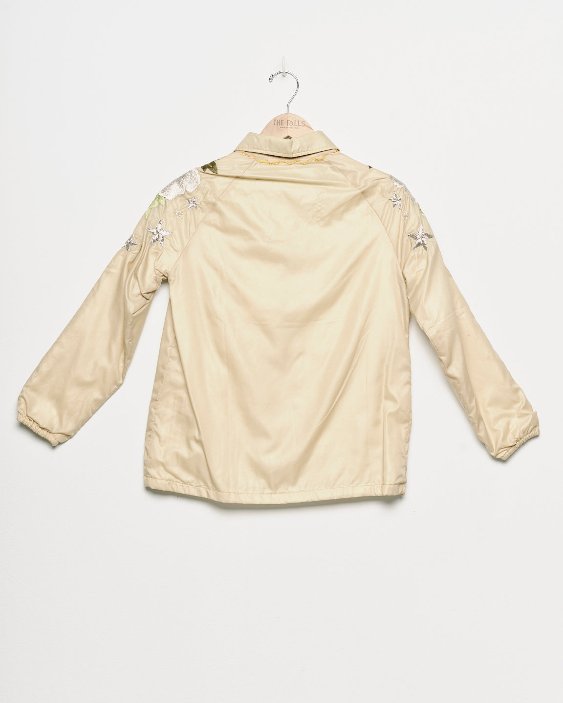 Upcycled windbreaker with floral embroidery, back view. 