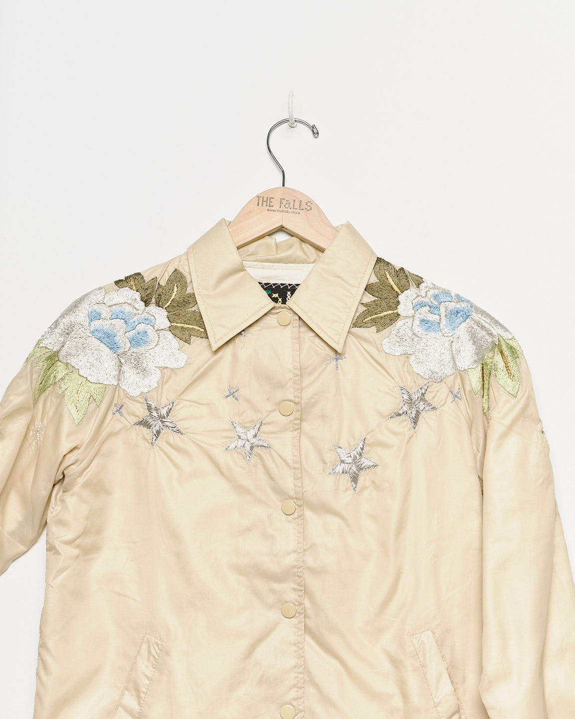 Upcycled windbreaker with floral embroidery, close up view. 