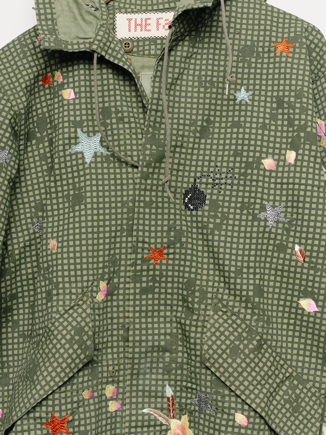 Upcycled parka with floral embroidery, close up view. 