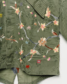 Upcycled parka with floral embroidery, close up view. 