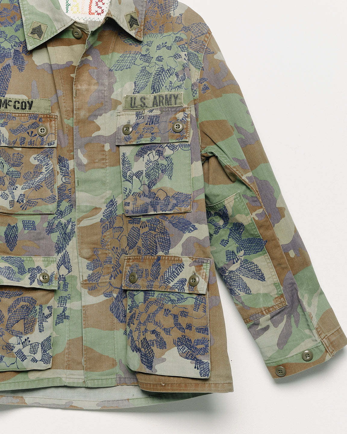 Vintage camouflage fatigue jacket with embroidered, close up view.