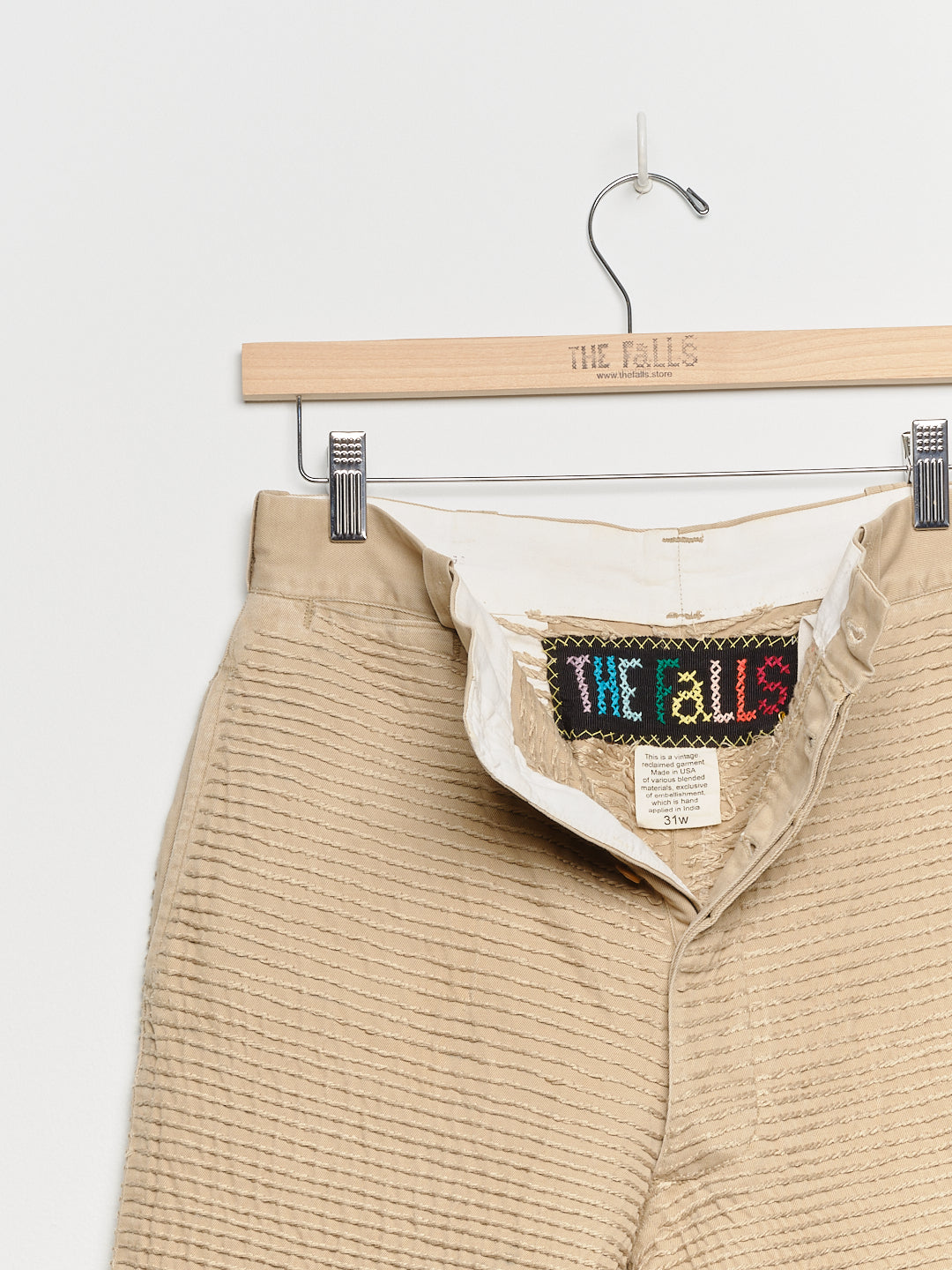 Upcycled chinos with embroidery, close up view. 