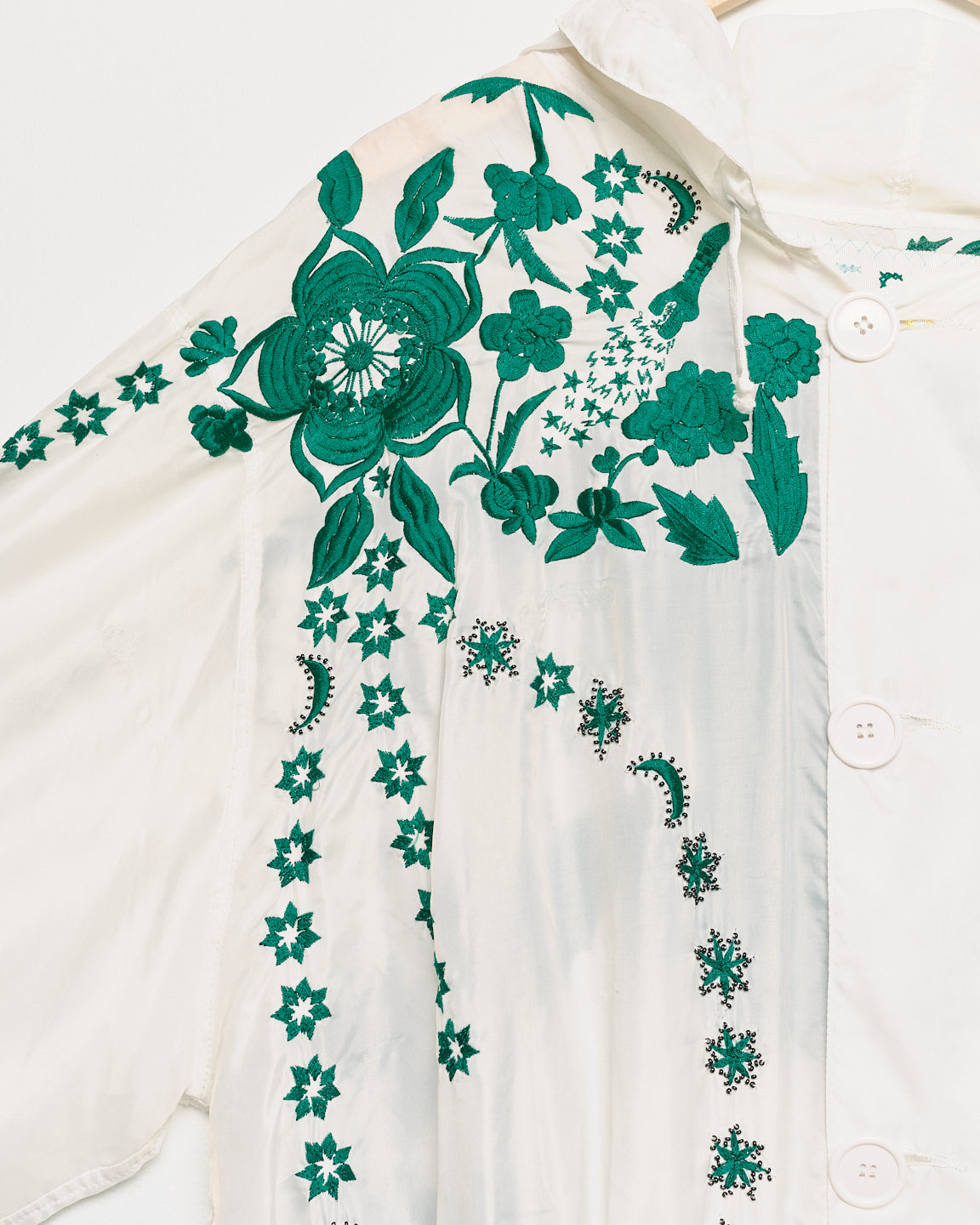 Vintage white parka with embroidered embellishments, close up view