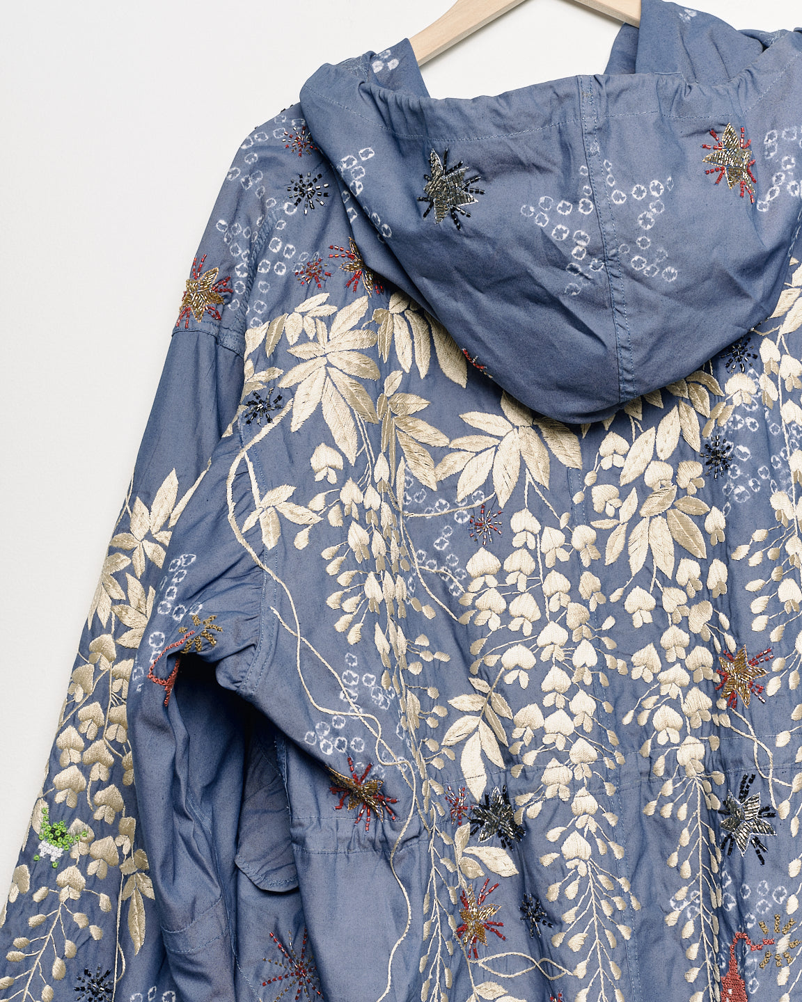 Upcycled parka with star and bomb embroidery, close up view. 