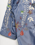 Upcycled parka with star and bomb embroidery, close up view. 