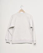 Upcycled sweatshirt with embroidery saying “hair force”, back view. 