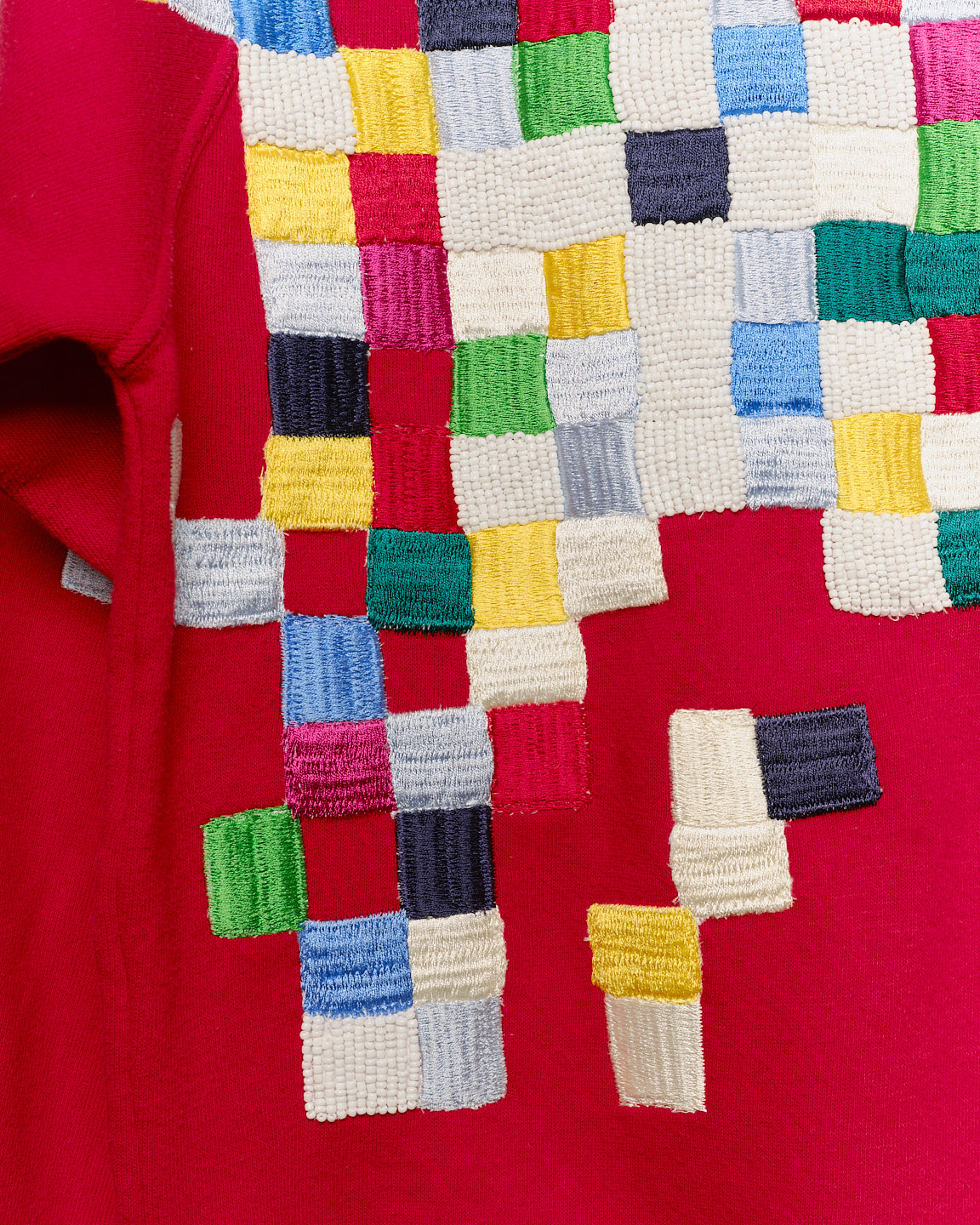 Upcycled sweatshirt with geometric embroidery, close up view. 