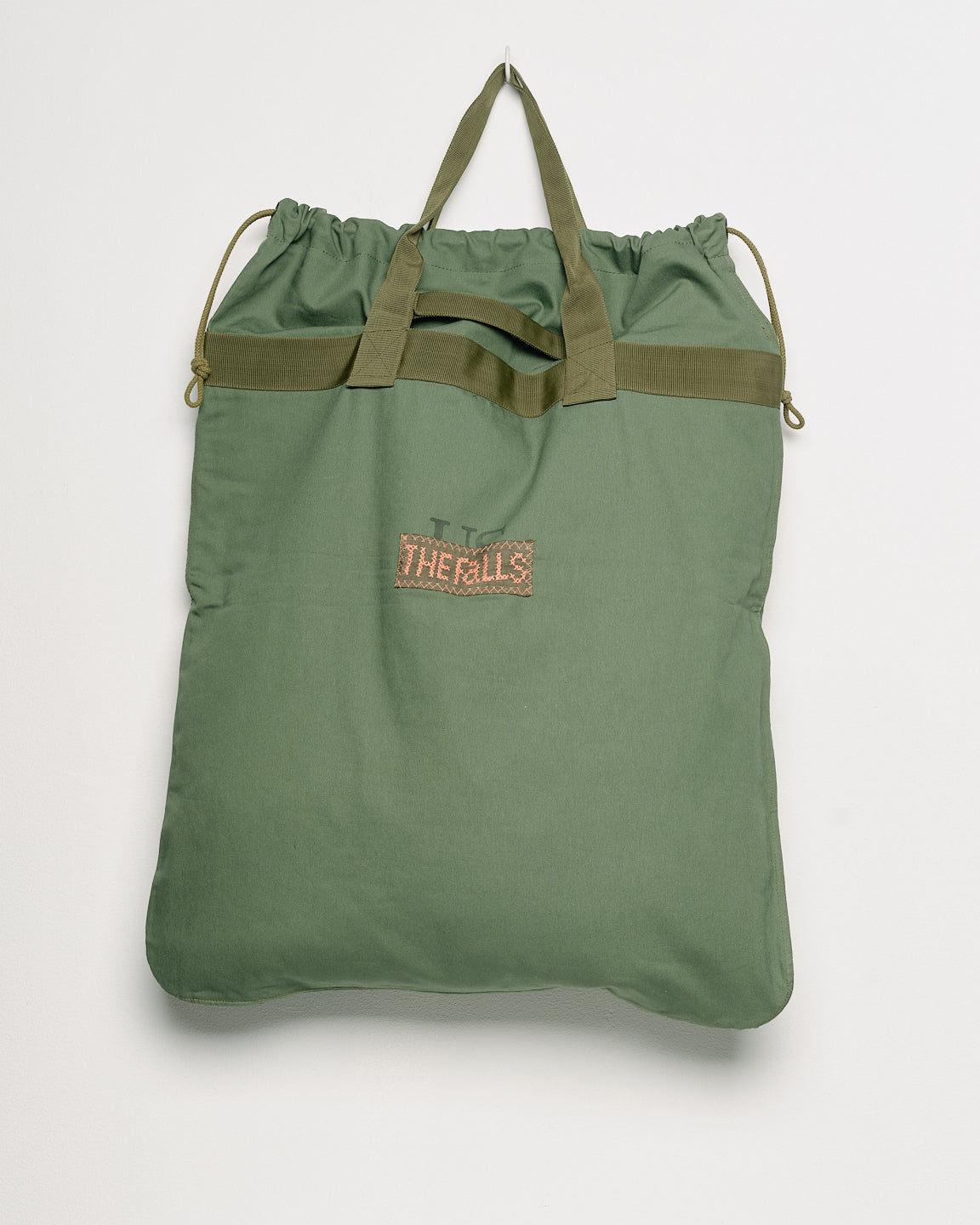 Vintage army surplus laundry tote with embroidered motifs, back view. 