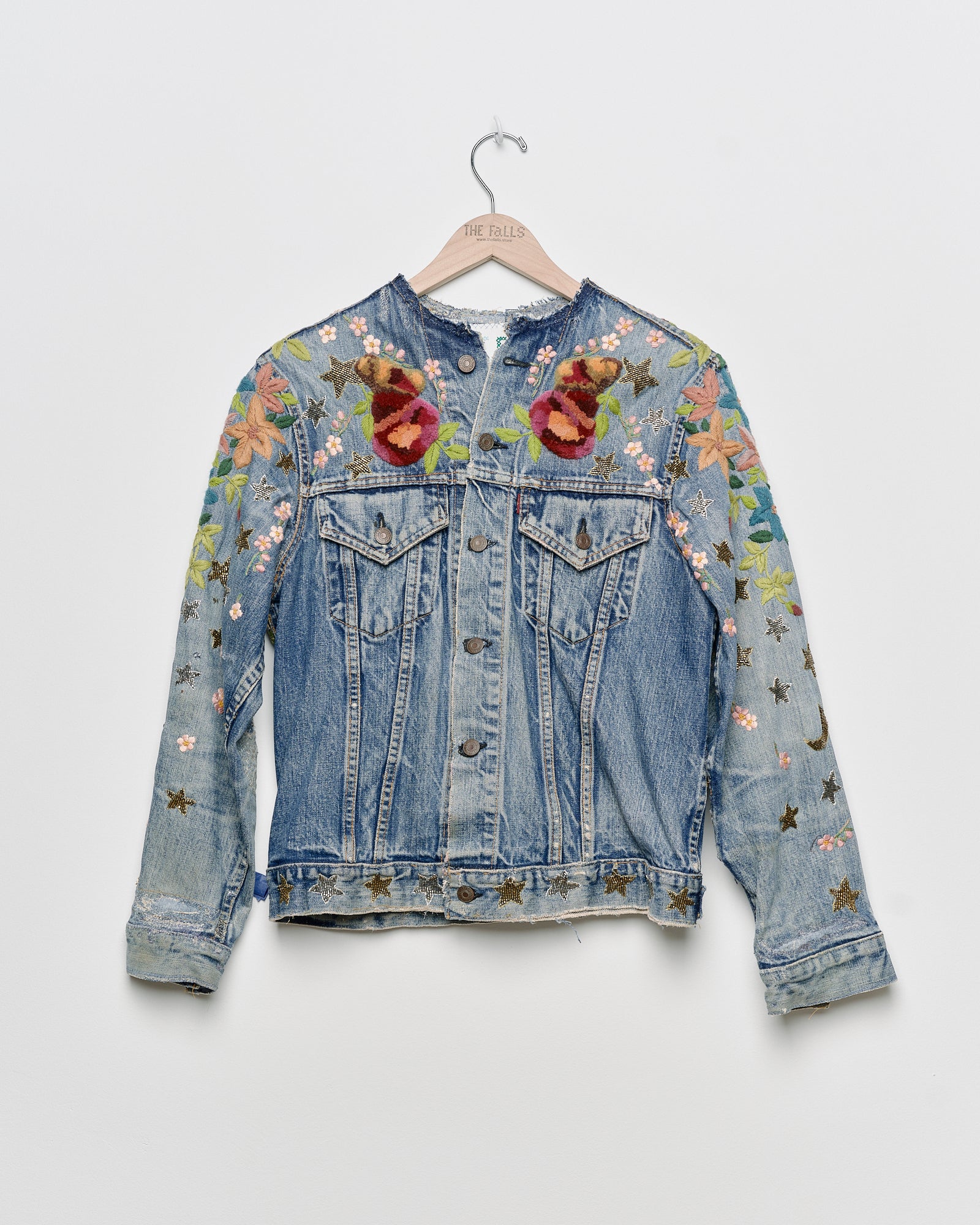 Vintage denim jacket with embroidery and tufted motifs, front view. 