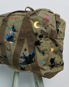 Upcycled aviator bag with embroidered embellishments, side view
