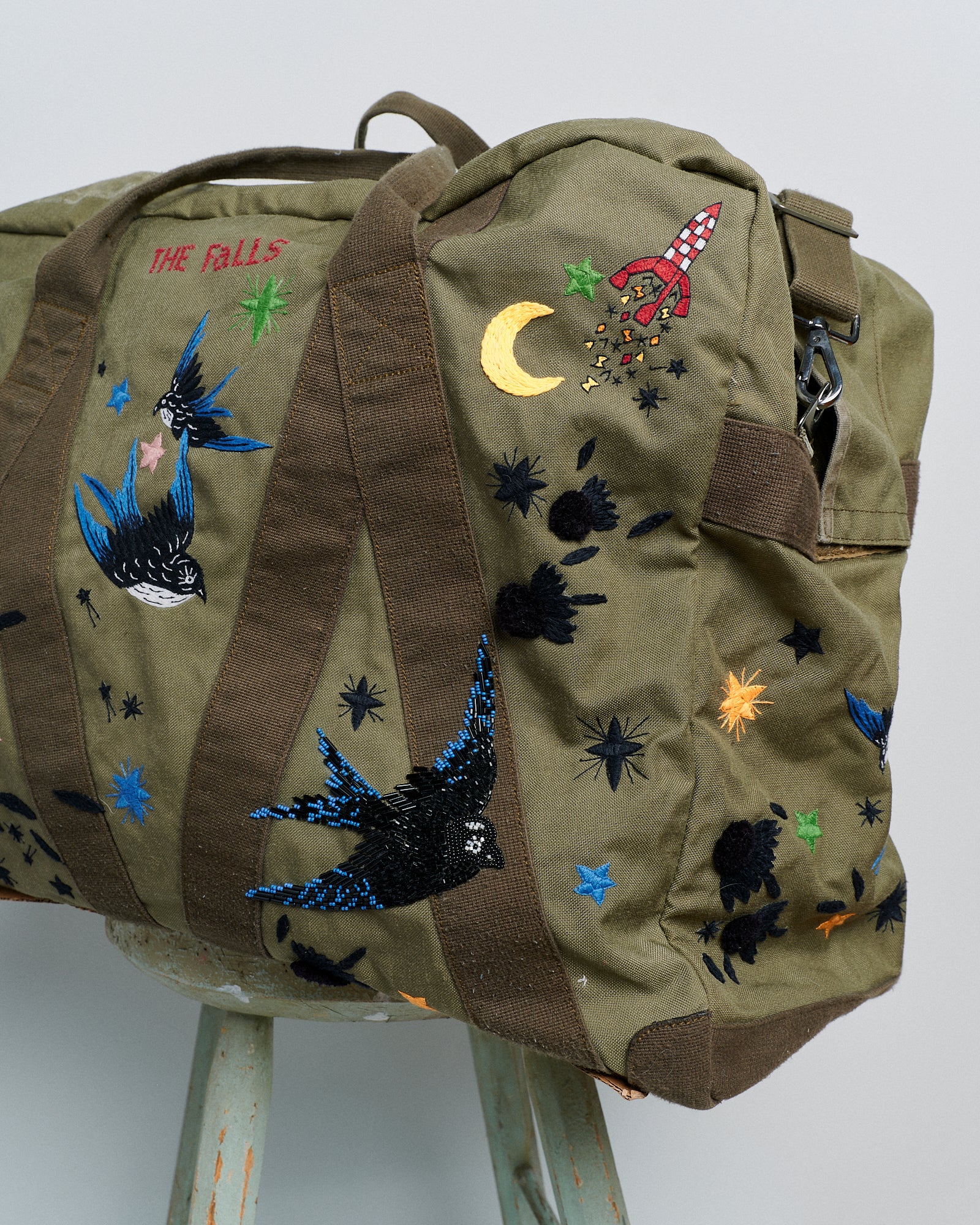 Upcycled aviator bag with embroidered embellishments, side view