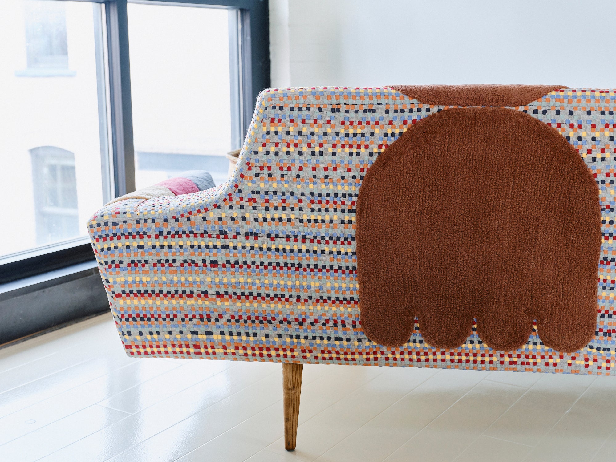 Upcycled sofa with tufted embellishments, close up view 