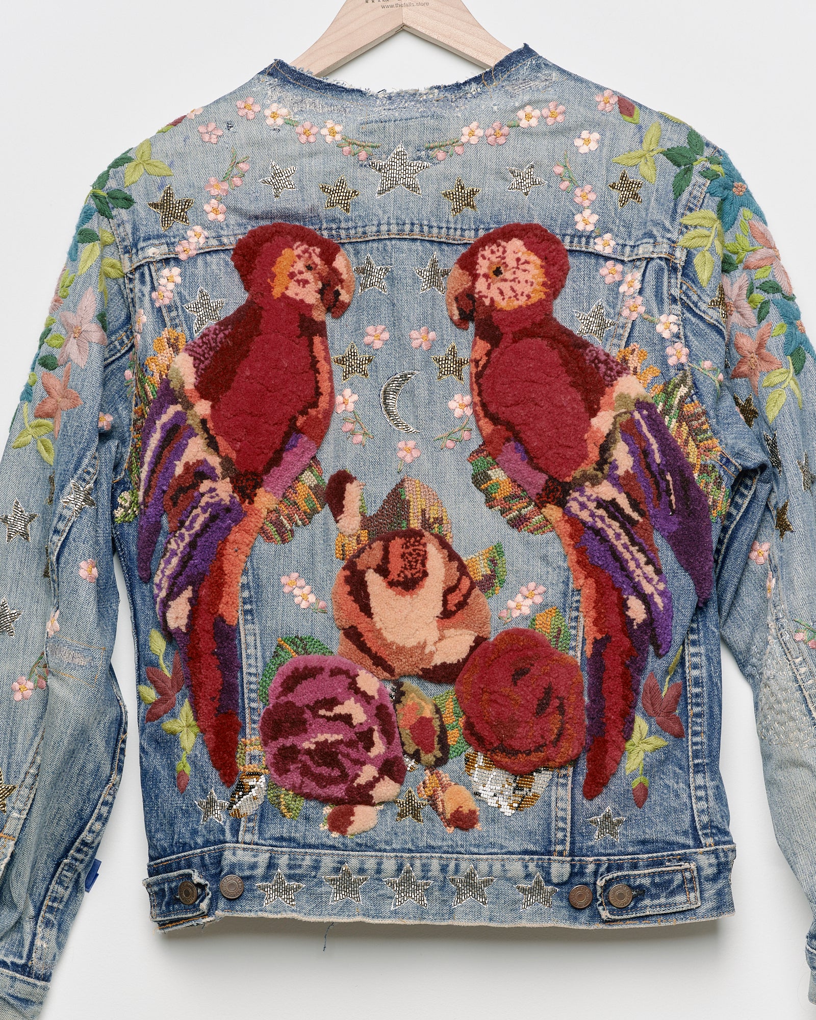 Vintage denim jacket with embroidery and tufted motifs, back view. 