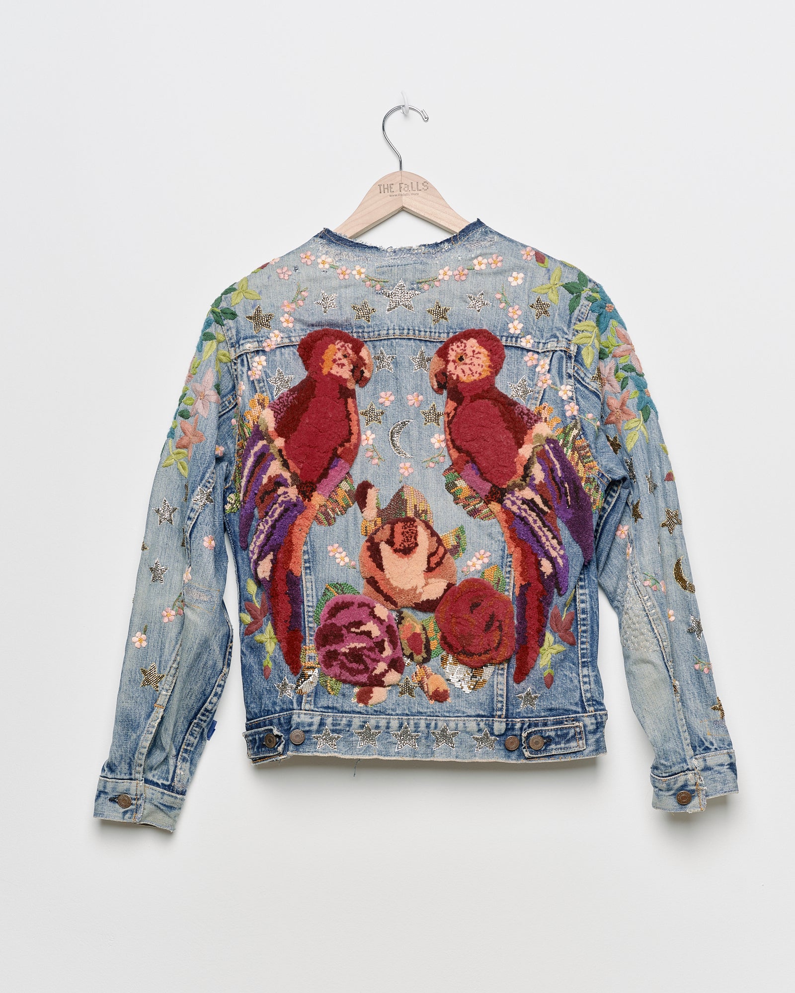 Vintage denim jacket with embroidery and tufted motifs, back view. 