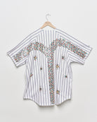 Upcycled baseball tee with embellishments, back view. 