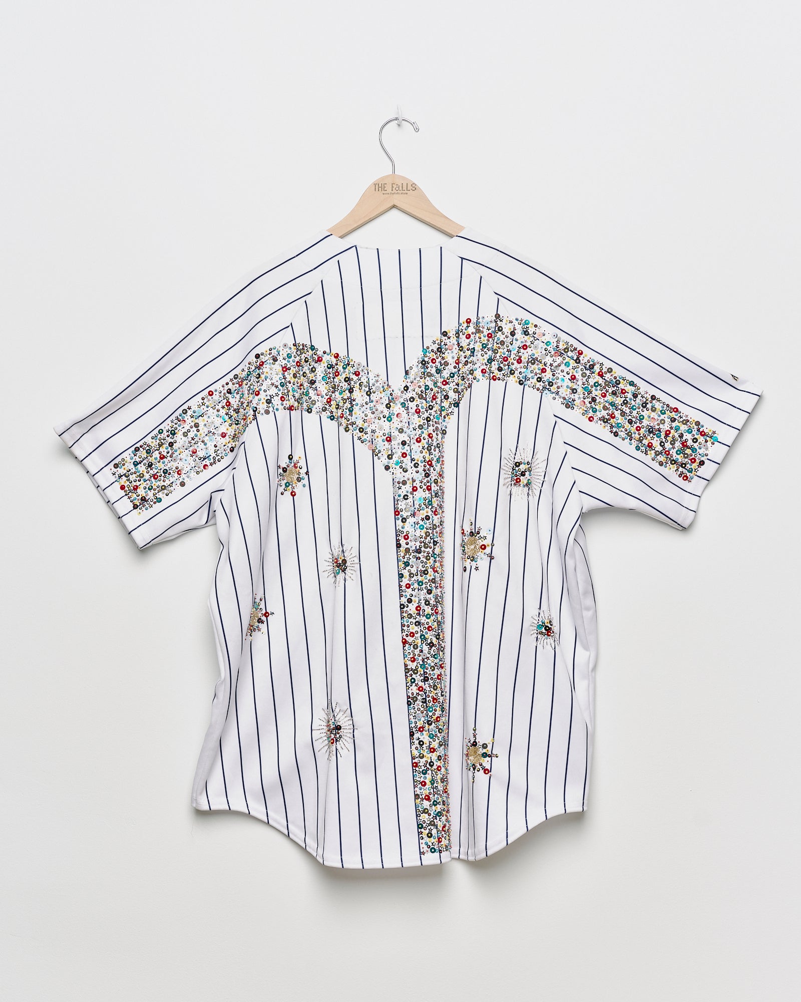 Upcycled baseball tee with embellishments, back view. 