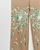 Upcycled wide leg khaki chino trousers with embroidered motif, close up view.