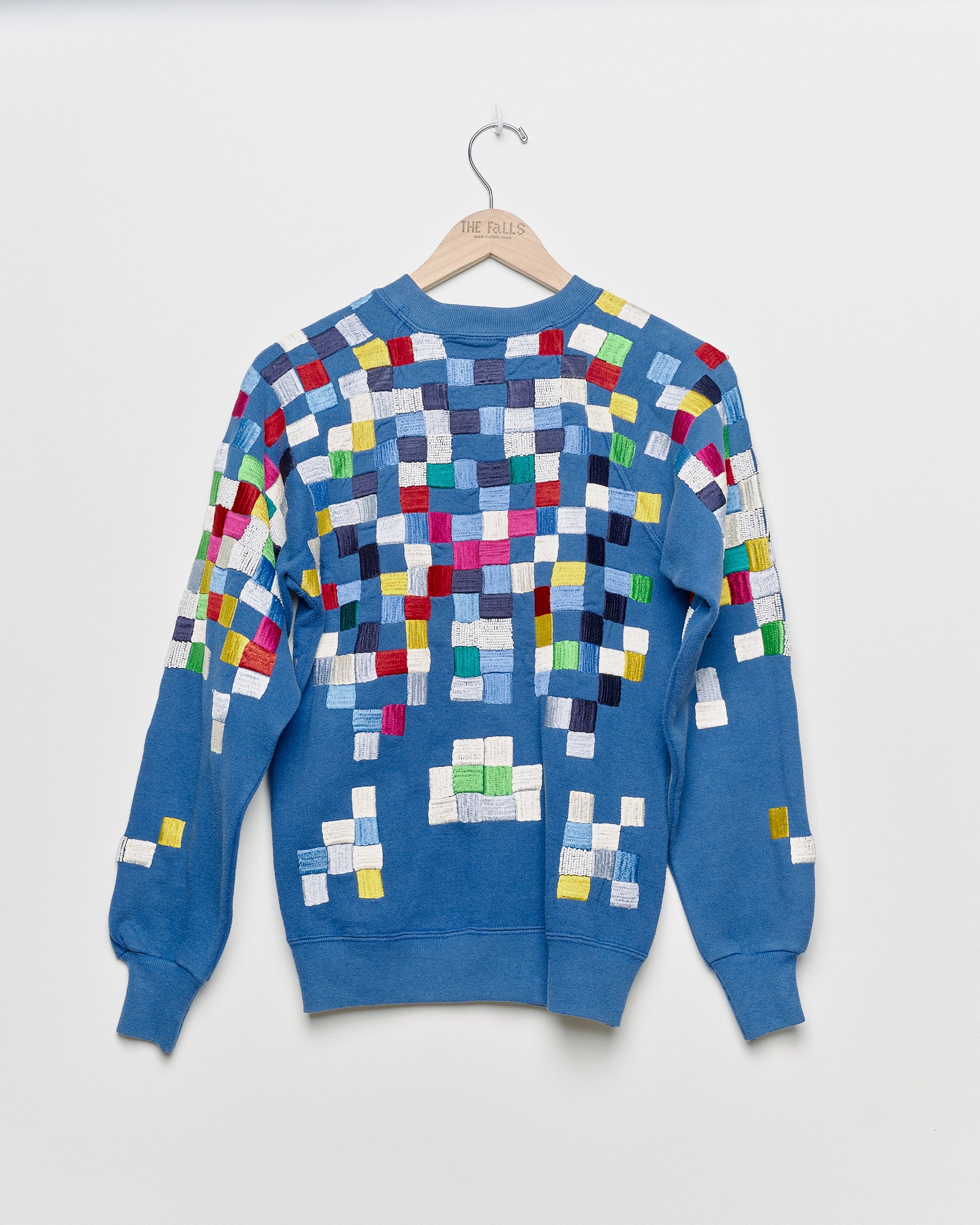 Upcycled sweatshirt with geometric embroidery, back view. 