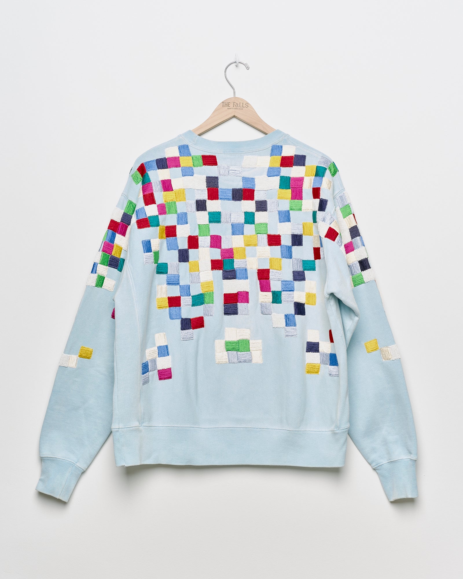 Upcycled sweatshirt with geometric embroidery, back view. 