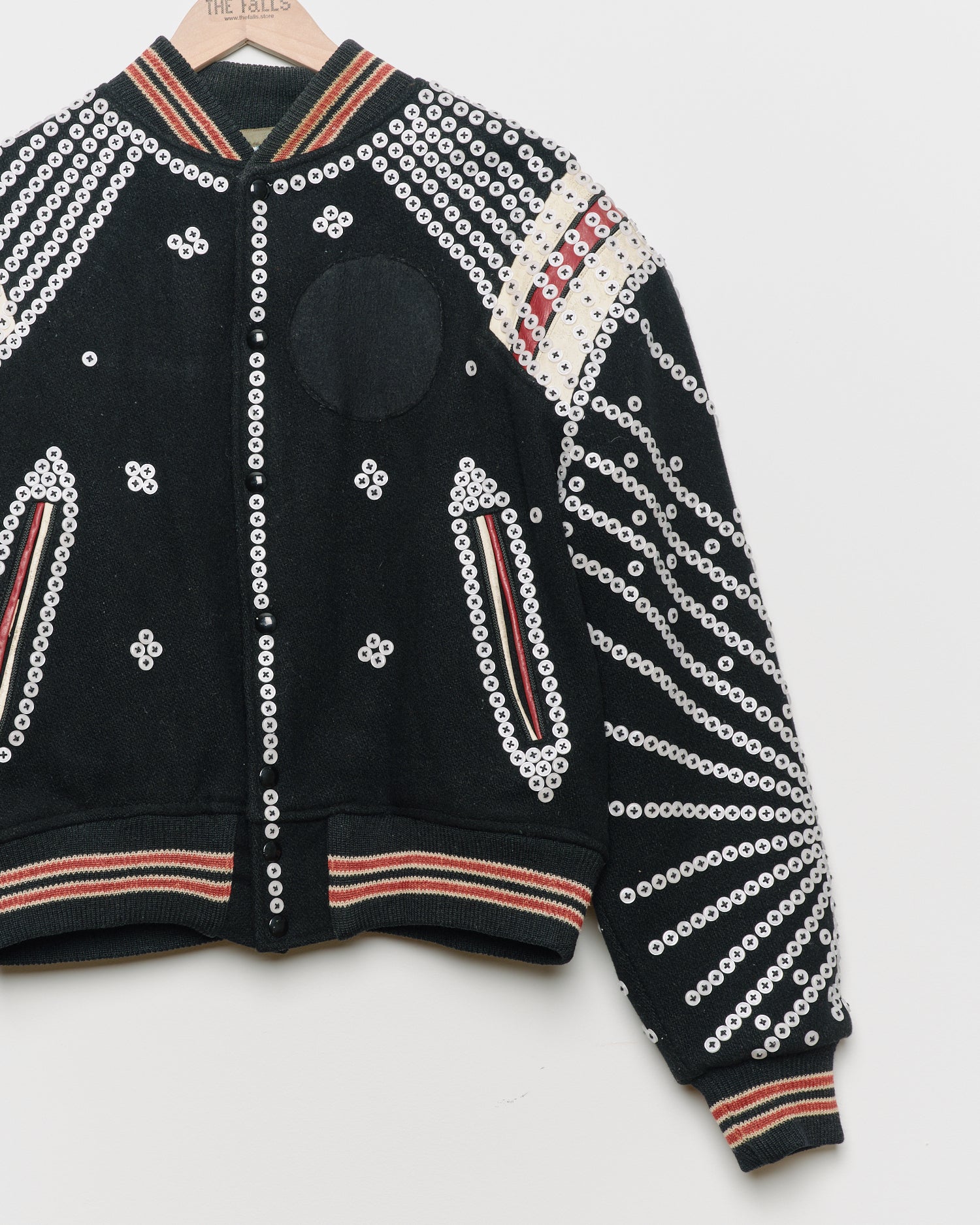 Black upcycled jacket with pearly buttons,
close up view.