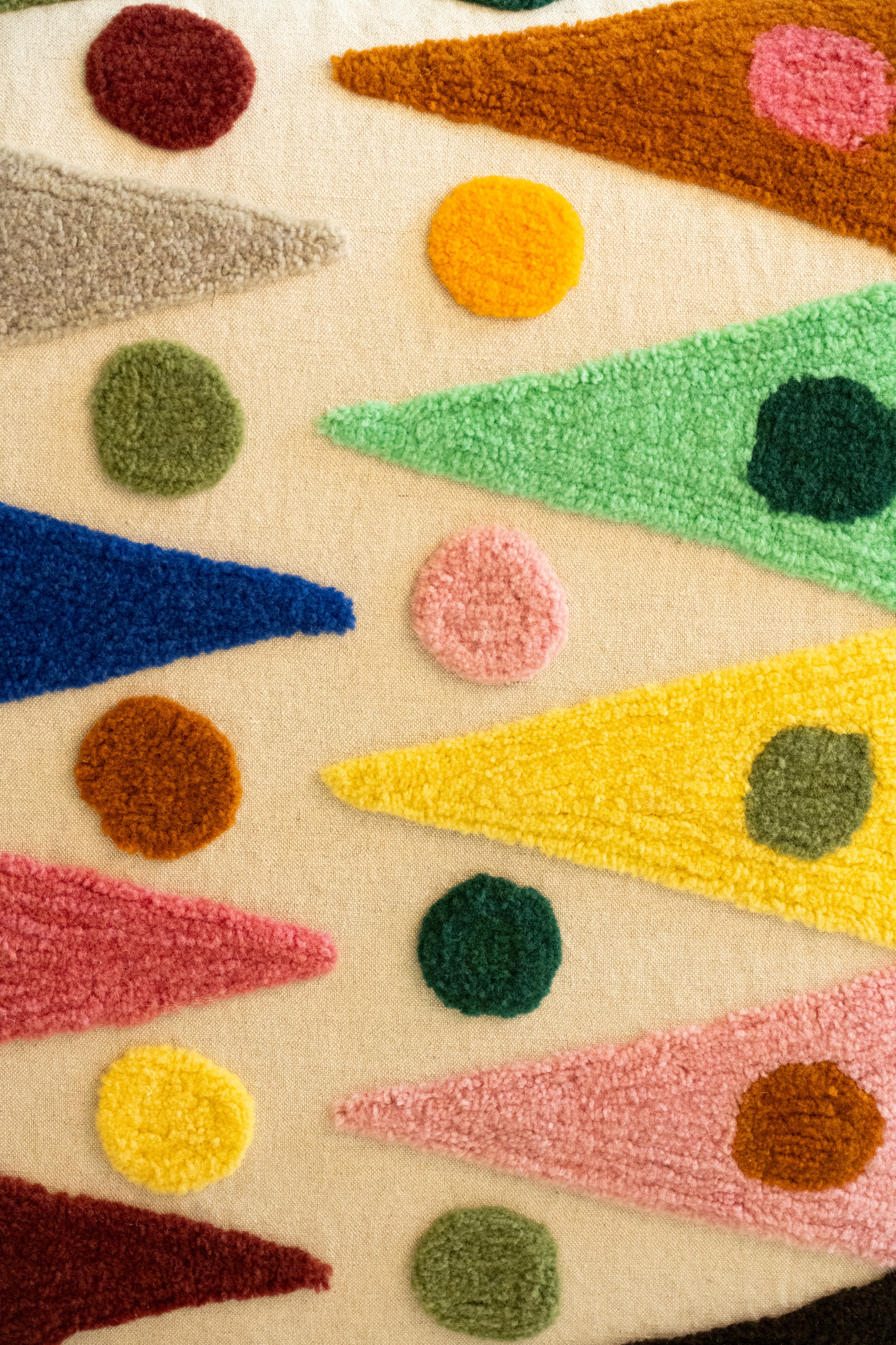 An upcycled tufted, sectional sofa with geometric wool triangles and diamonds pattern, close up back view.