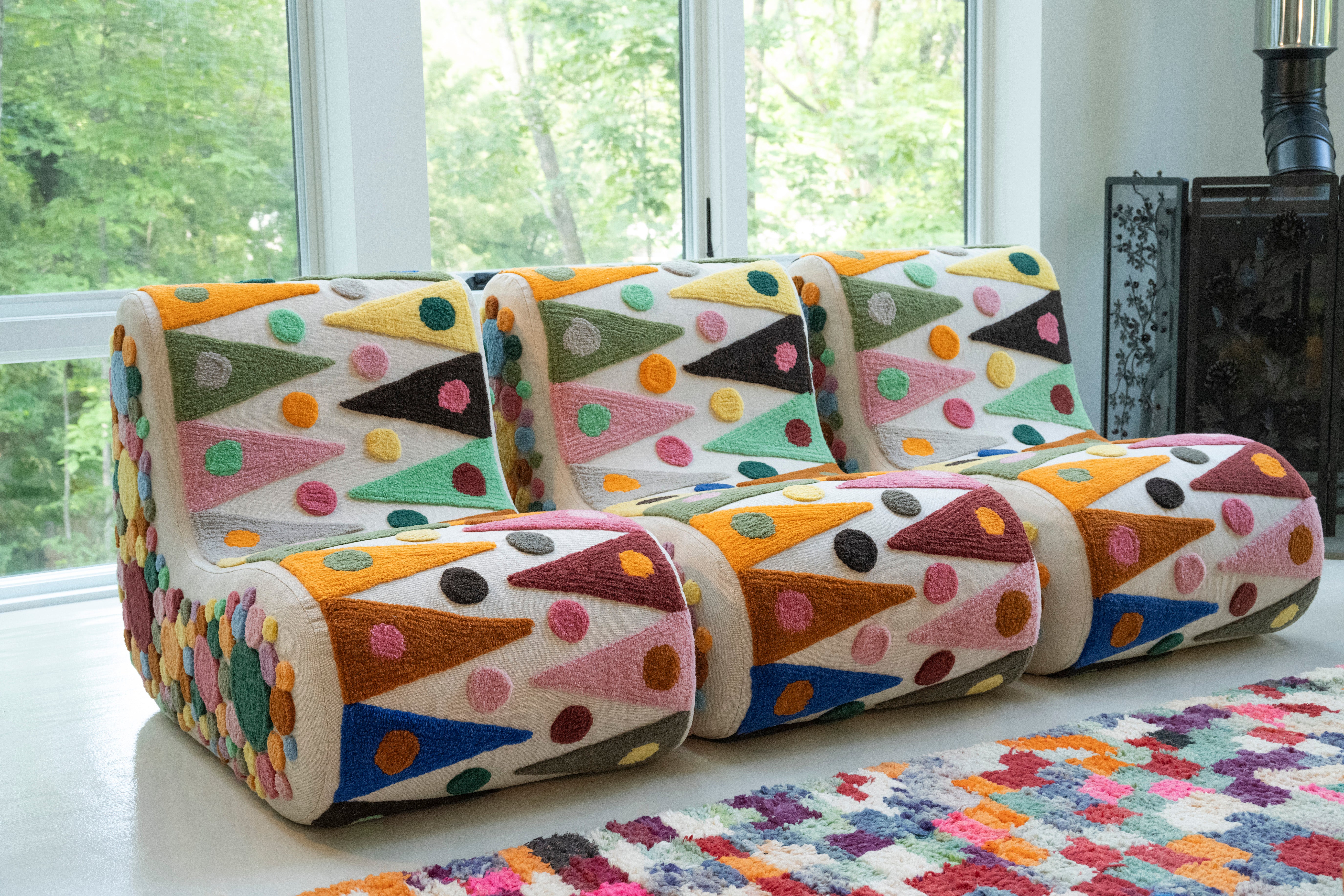 An upcycled tufted, sectional sofa with geometric wool triangles and diamonds pattern, front view.