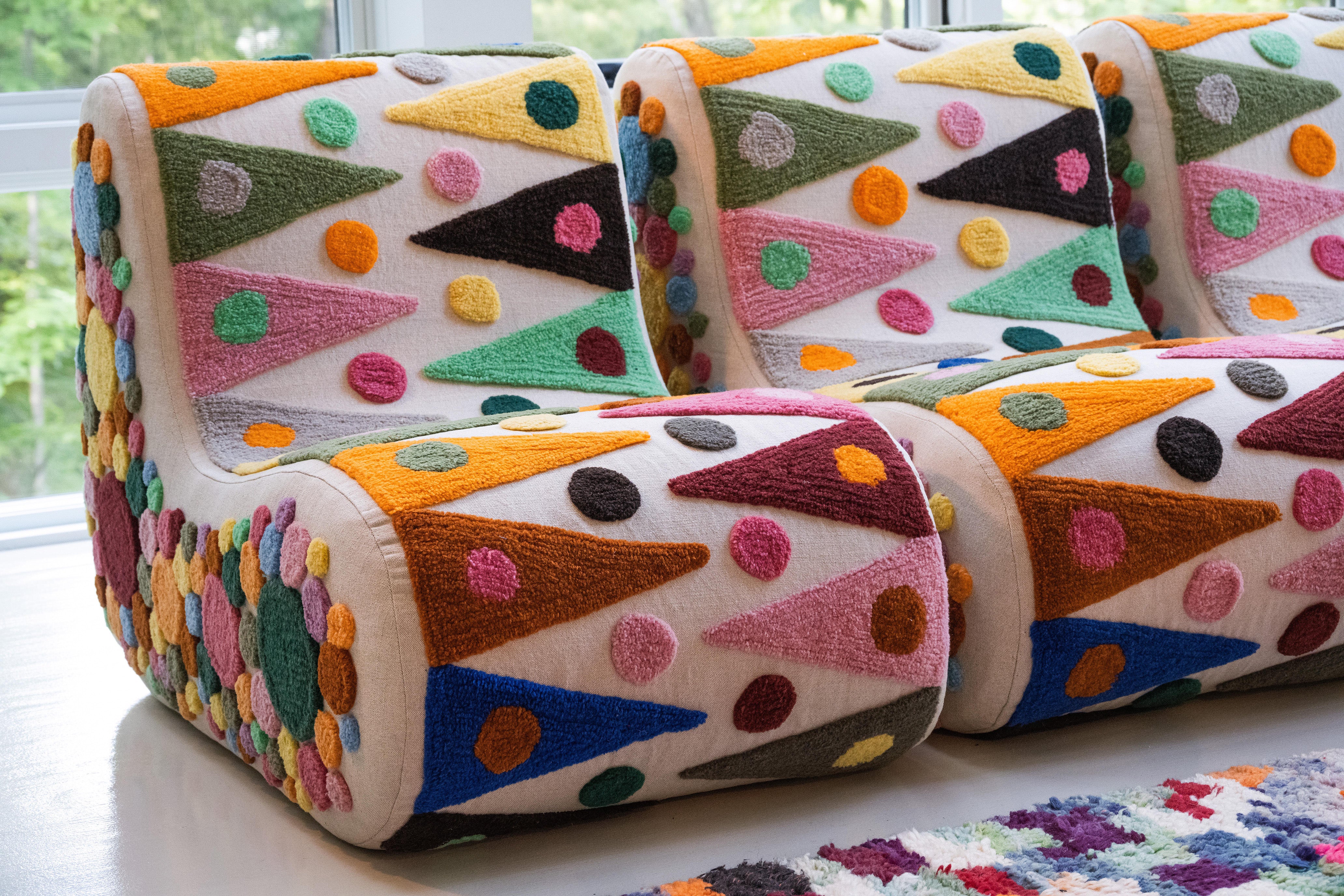 An upcycled tufted, sectional sofa with geometric wool triangles and diamonds pattern, front close up view. 