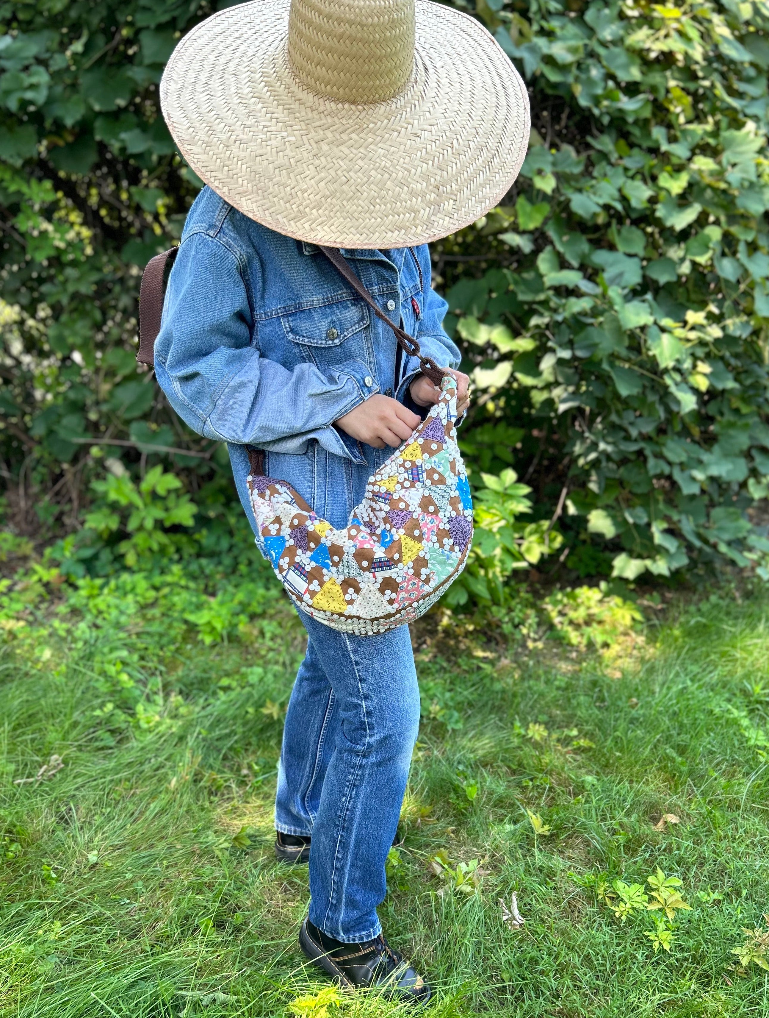 Sling bag with embroidered and button embellishments, front view