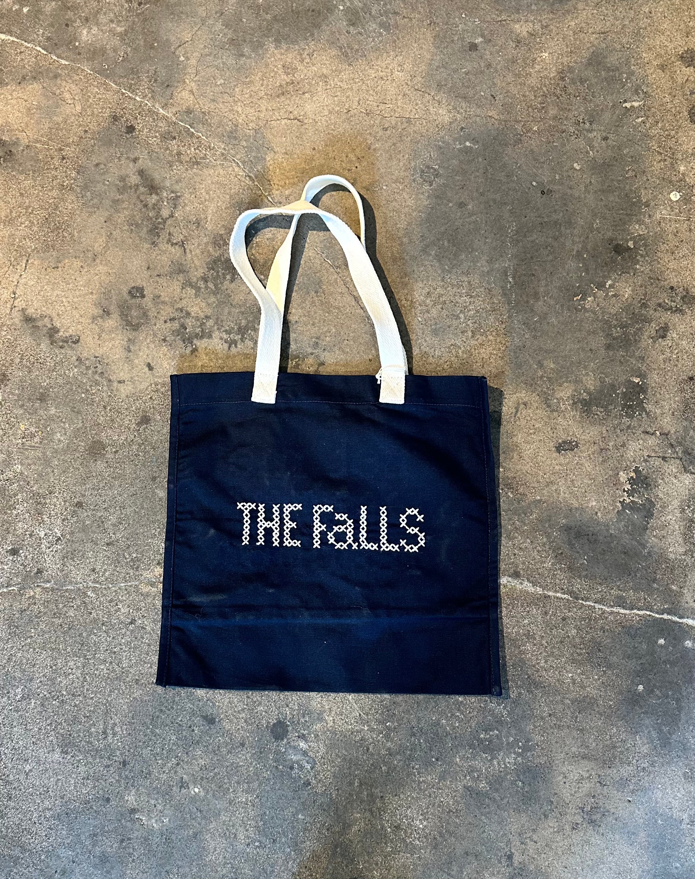 Bag with “Let me use my teacher voice” embroidered in cross stitch, back view.