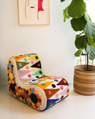 An upcycled tufted, sectional sofa with geometric wool triangles and diamonds pattern, side view.