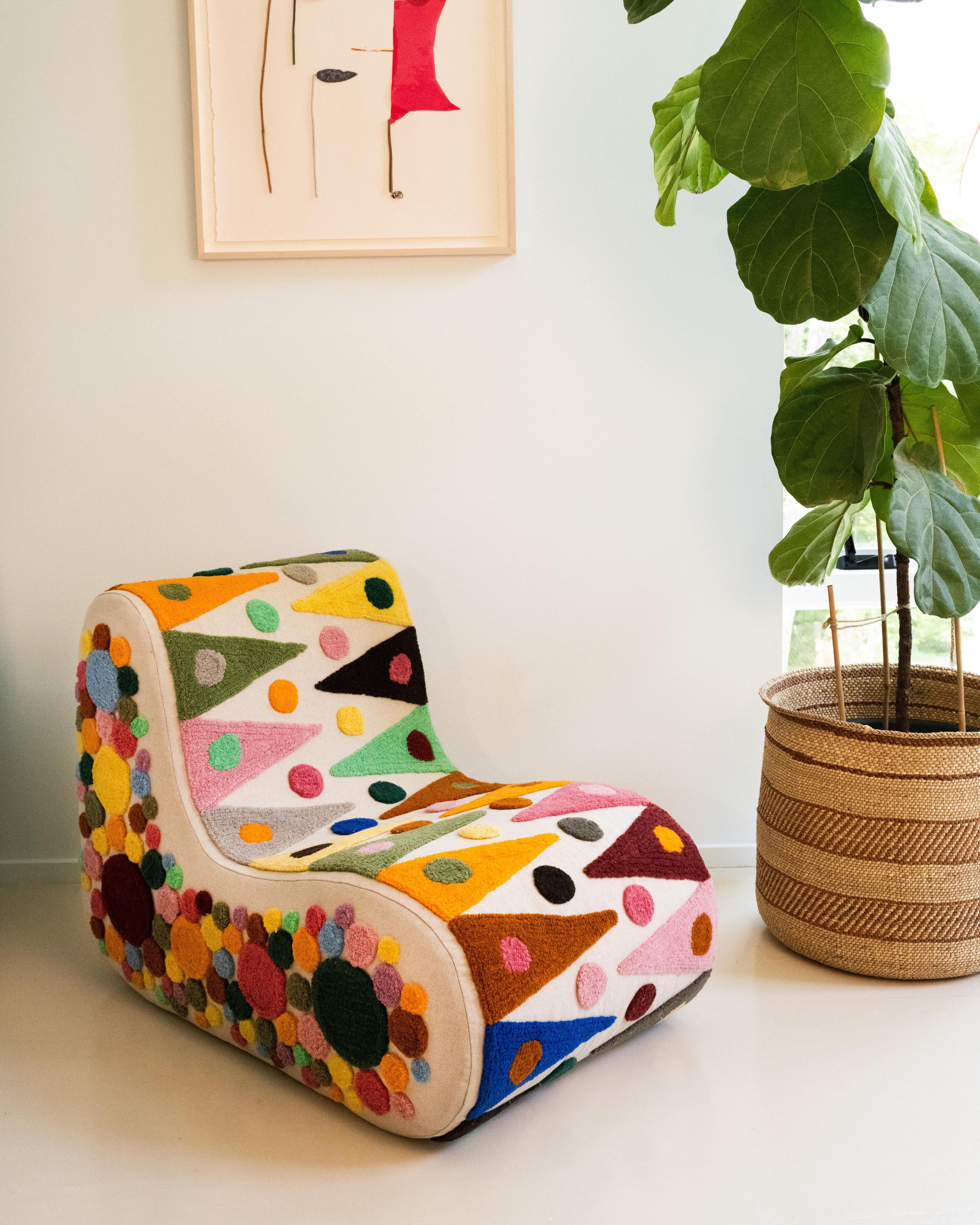 An upcycled tufted, sectional sofa with geometric wool triangles and diamonds pattern, side view.
